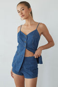 Woman wearing a blue denim outfit on a plain background