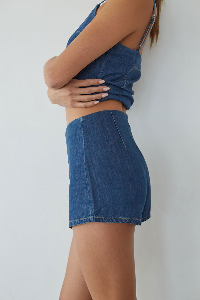 Person wearing a blue denim outfit against a white background