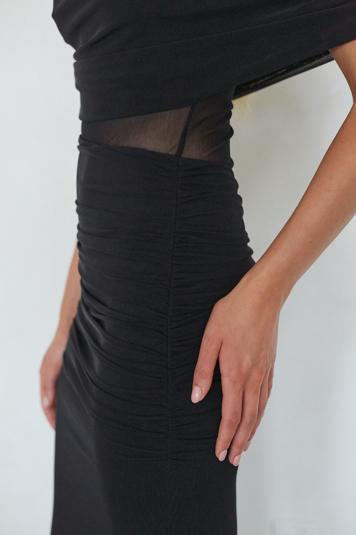 Black dress with sheer mesh detail on a white background