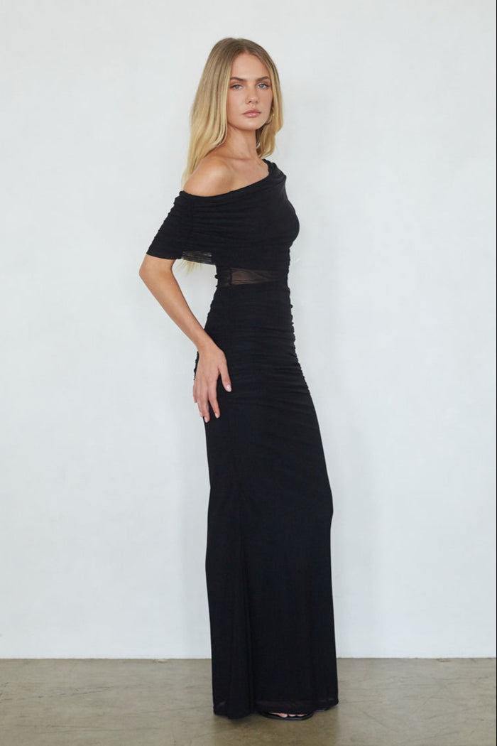 Woman wearing a black off-shoulder gown against a white background