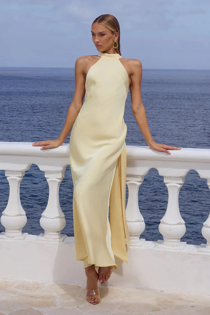 yellow-image | Woman in a yellow dress standing on a balcony with ocean view