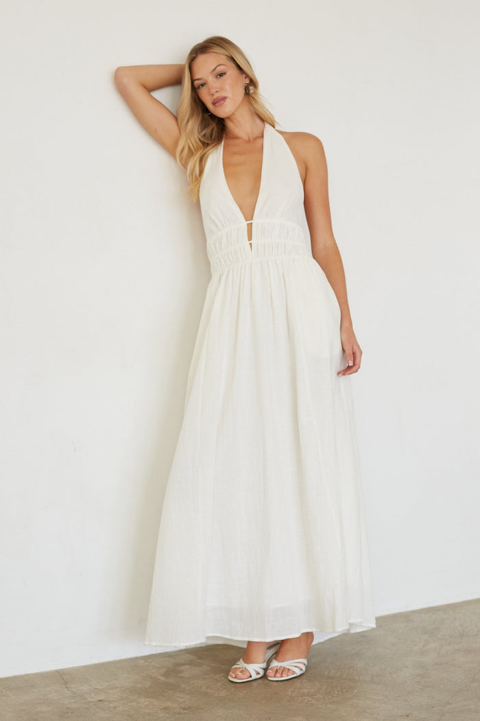 Woman wearing a white dress against a plain background