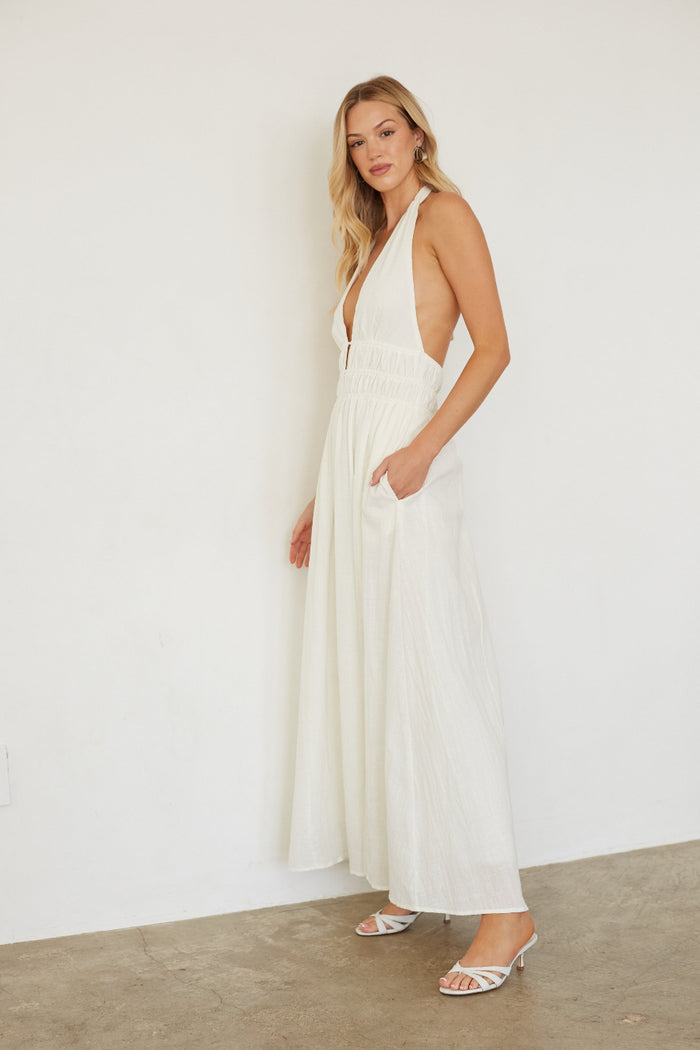 Woman wearing a white dress against a plain background