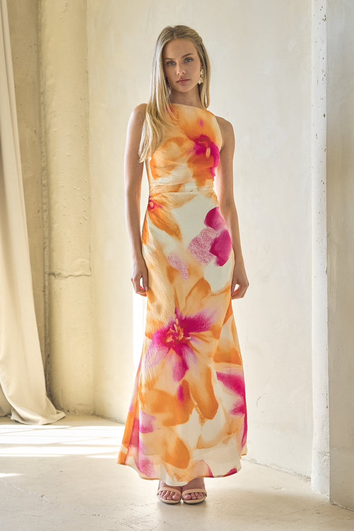 Woman wearing a floral dress standing in a bright room with curtains.