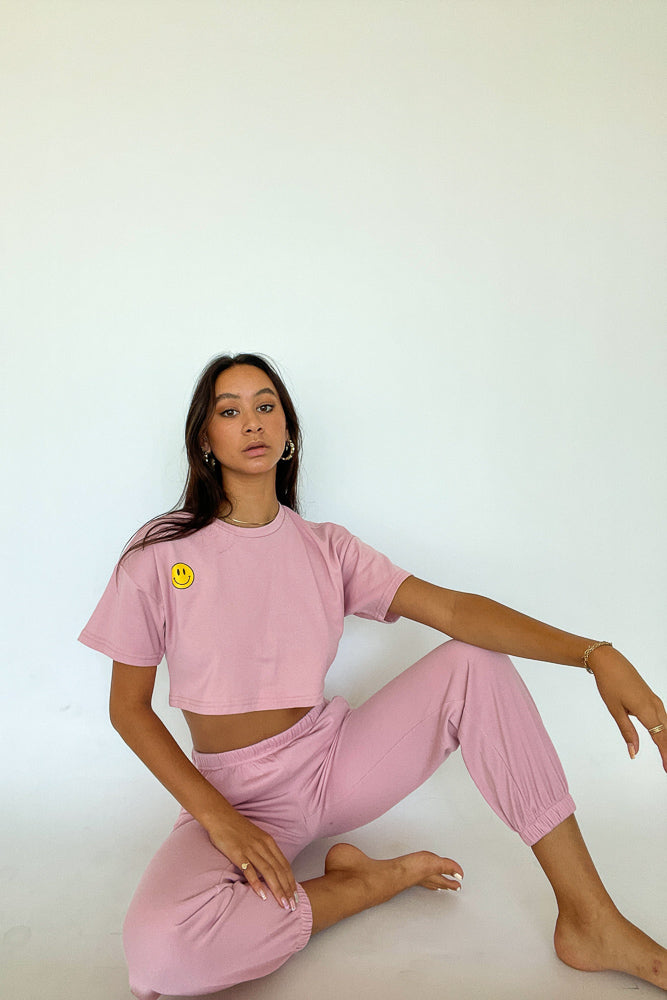 Model posing in pink crop top