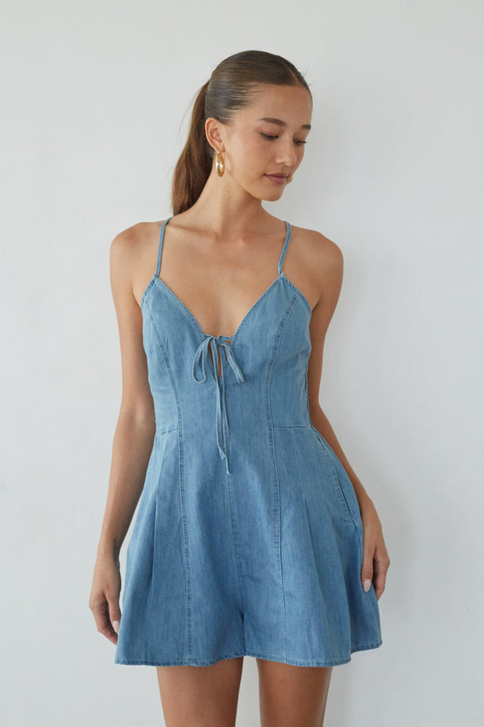 Woman wearing a blue denim dress against a white background