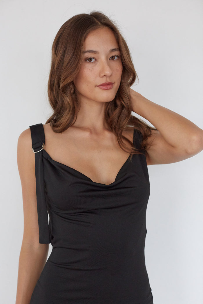 Woman wearing a black dress against a white background