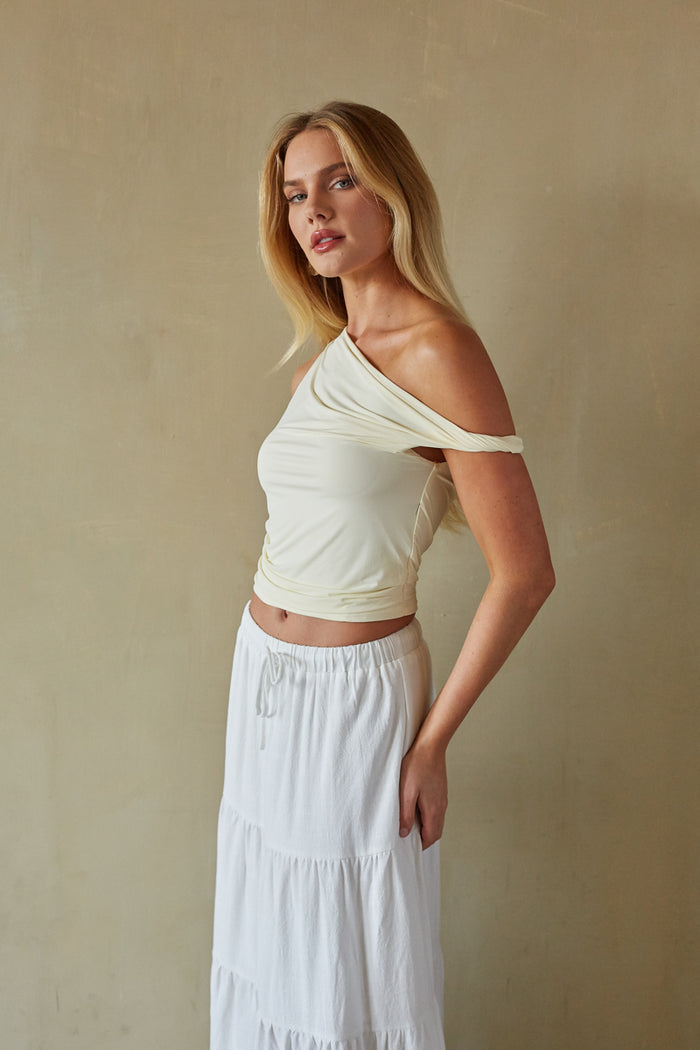 Side-image | Off the Shoulder Twist Top | side view focusing on the flattering silhouette of the top and the skirt's slit.