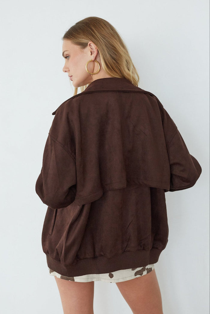 Person wearing a brown jacket against a white background