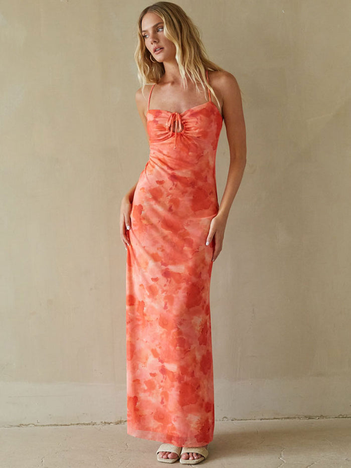 Woman wearing a coral tie-dye dress against a beige background