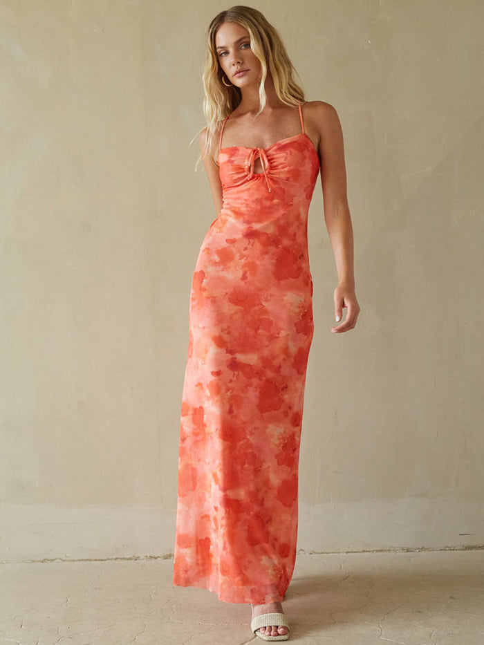 Woman wearing a coral tie-dye dress against a beige background