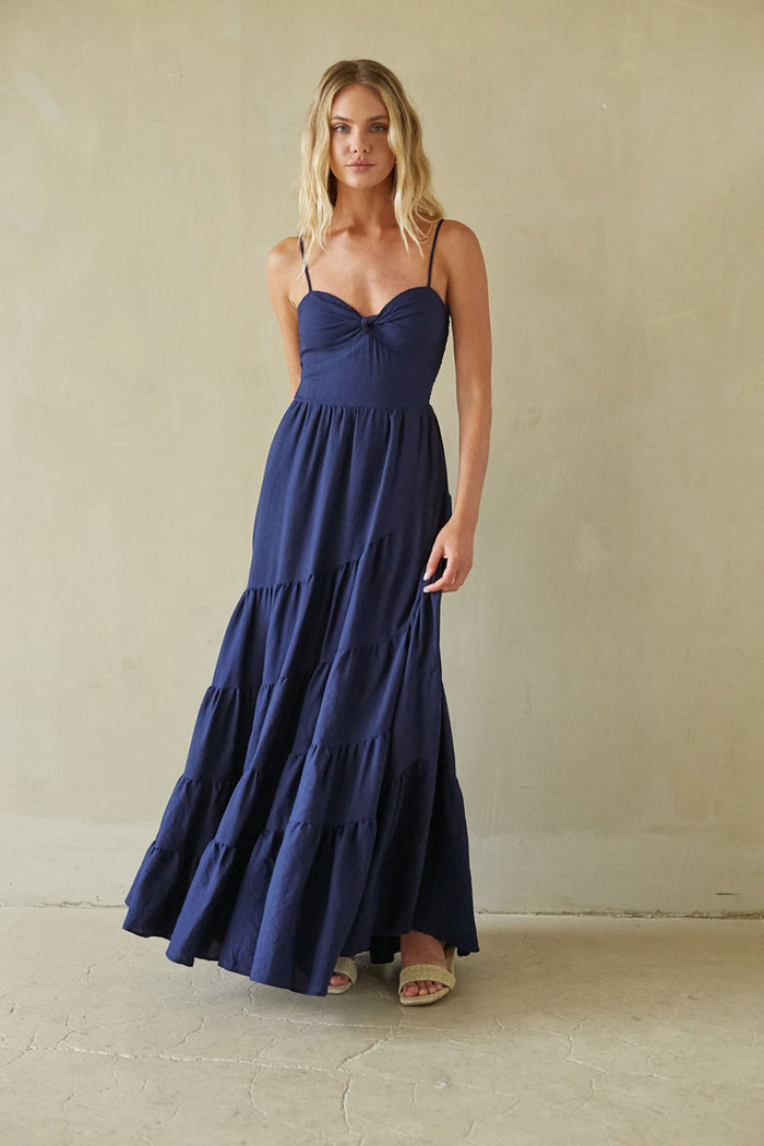blue-image | Woman wearing a navy blue dress against a beige background