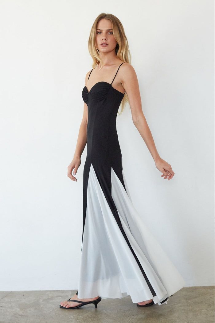 Woman wearing a black and white dress against a plain background