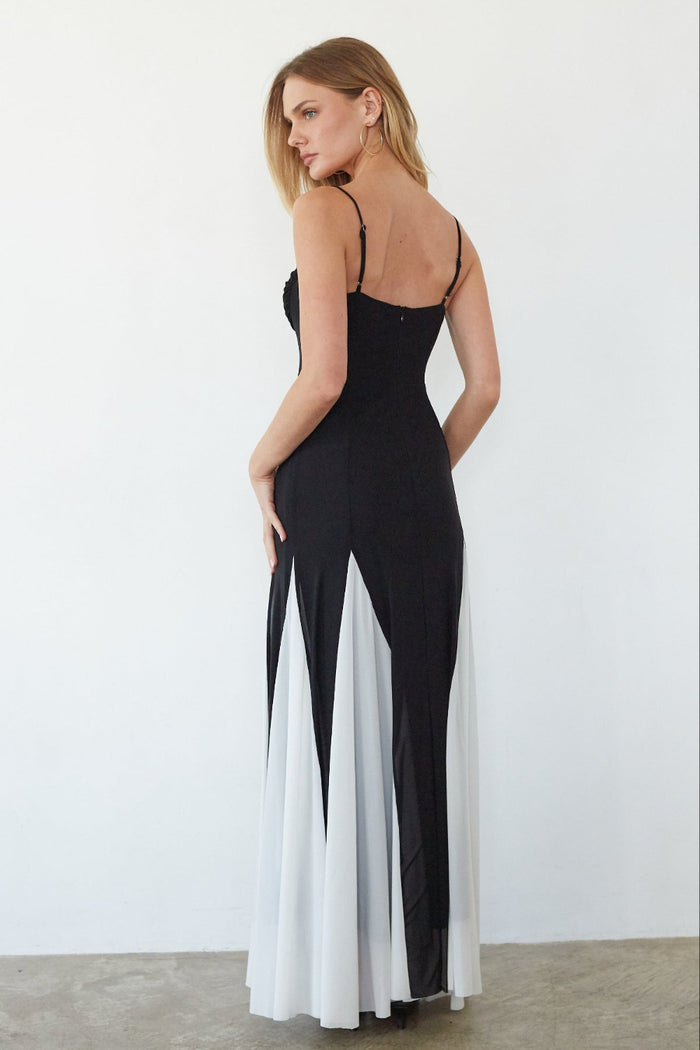 Woman wearing a black and white dress against a plain background