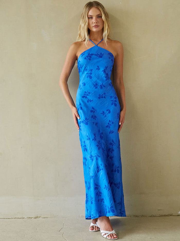 blue-image | Woman wearing a blue floral dress against a beige wall