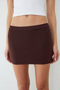 Brown mini skirt worn by a person on a white background