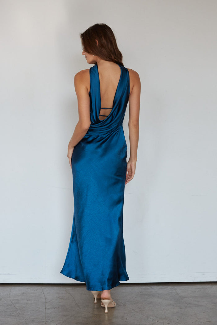Woman wearing a blue satin dress with a plain background