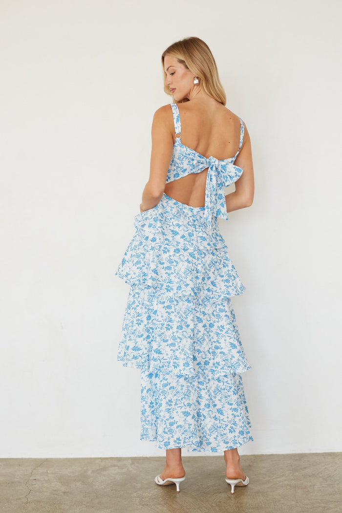 Woman wearing a blue floral dress with a white background