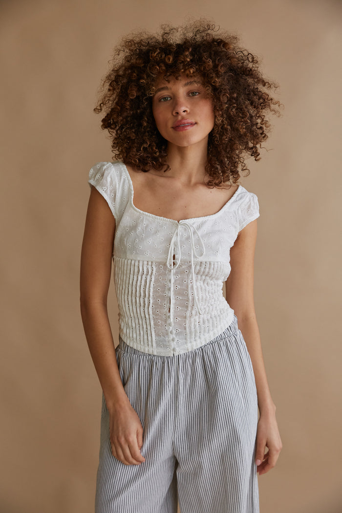 white wide scoop neck puff sleeve pleated blouse with floral eyelet