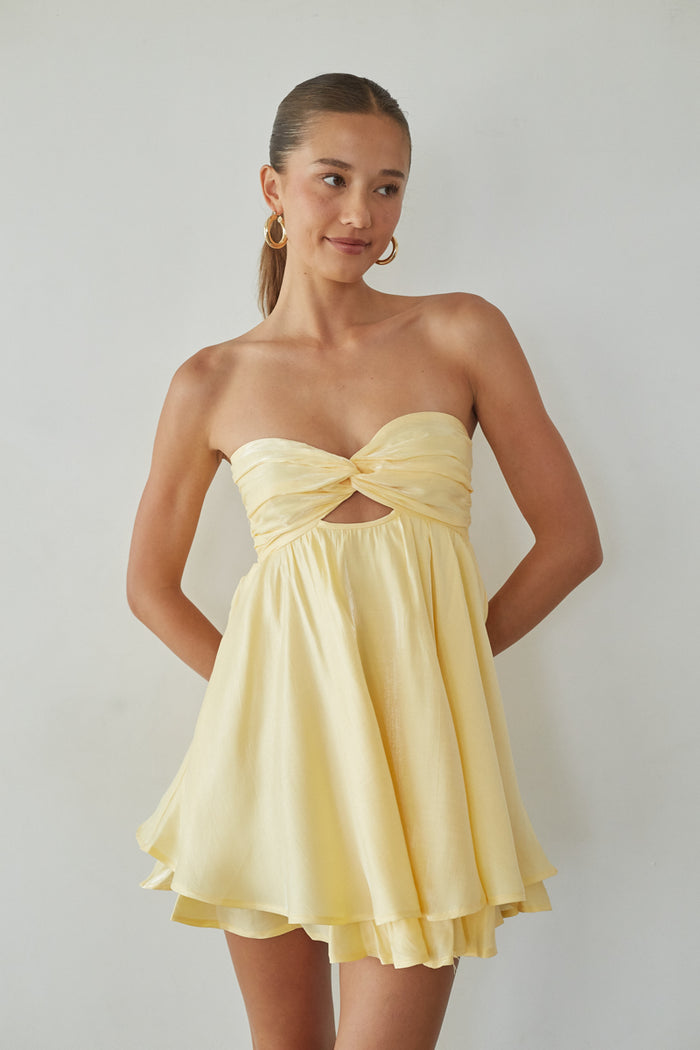 yellow-image | Woman wearing a yellow strapless dress against a plain background