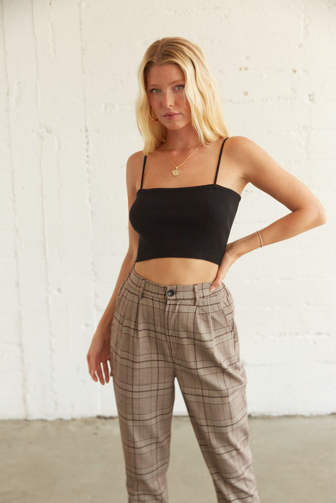 Cropped black ribbed tank top with spaghetti straps.