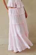 Woman wearing a pink tiered dress against a beige background