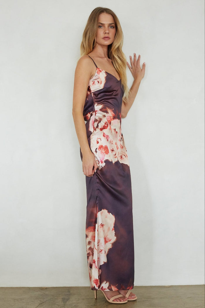 Woman wearing a floral slip dress against a plain background