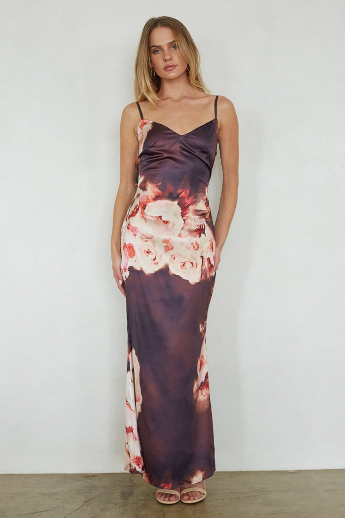 Woman wearing a floral slip dress against a plain background
