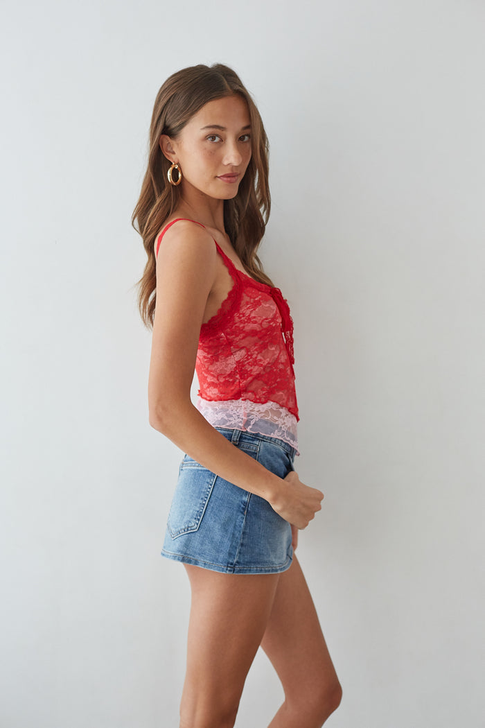 side-image | red lace tank top | denim mini skirt | laid-back summer style | feminine red lace top with a bow tie and a denim mini skirt, offering a relaxed yet trendy vibe for the warmer months