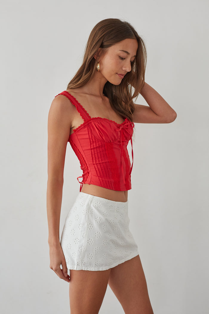Style-image | Eyelet Lace Mini Skort | styled with a casual yet chic aesthetic, pairing the red top with the white eyelet lace skort for a vibrant, youthful look.