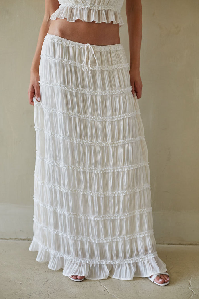 White ruffled skirt worn by a person against a neutral background