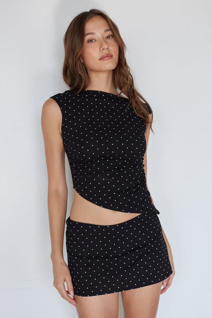 Woman wearing a black dress with cut-out design against a white background