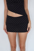 Black polka dot skirt with cut-out design on a white background