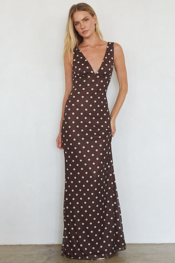 brown-image | Woman wearing a brown polka dot dress against a white background