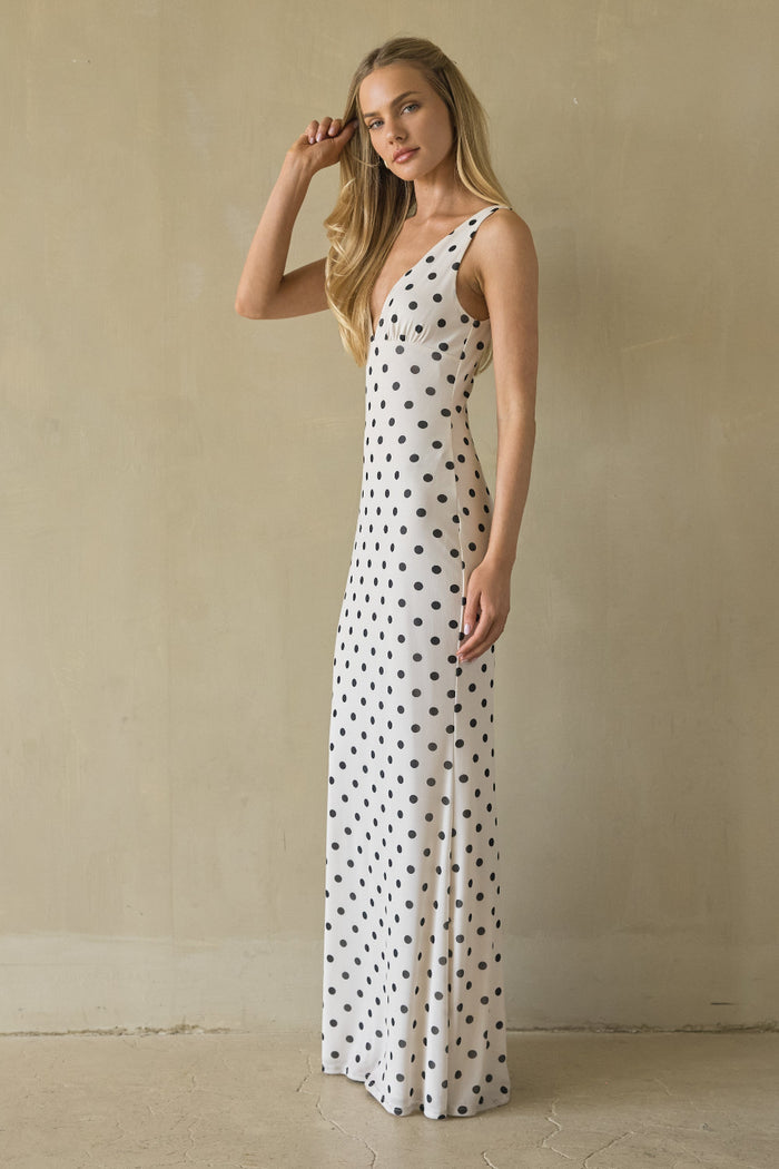 Woman wearing a polka dot dress against a beige wall