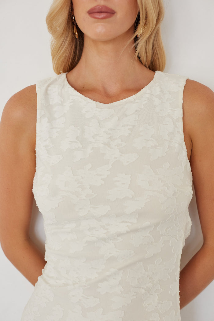 White textured sleeveless dress worn by a model against a plain background