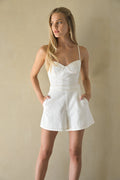 Woman wearing a white dress against a beige background