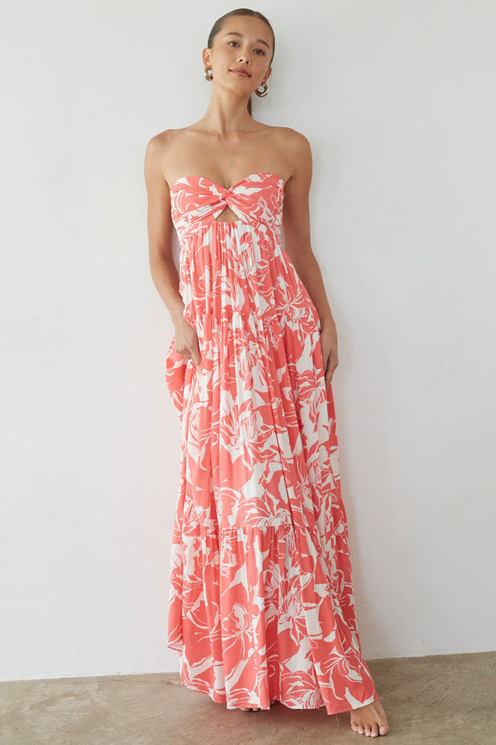 pink-image | Woman wearing a strapless floral dress against a white background