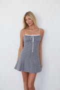 blue-image | Woman wearing a blue and white checkered dress against a white background