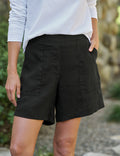 Person wearing black shorts with a blurred natural background