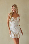 pink-image | Woman wearing a floral dress against a plain background