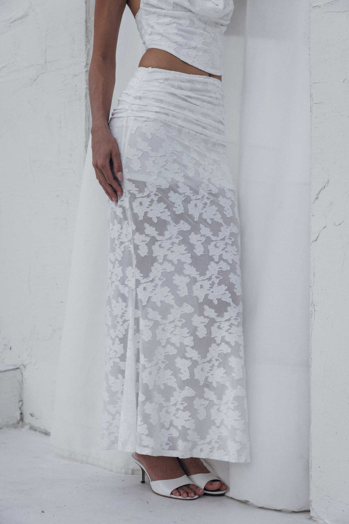 Woman wearing a white lace dress against a white background
