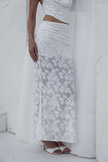 Woman wearing a white lace dress against a white background