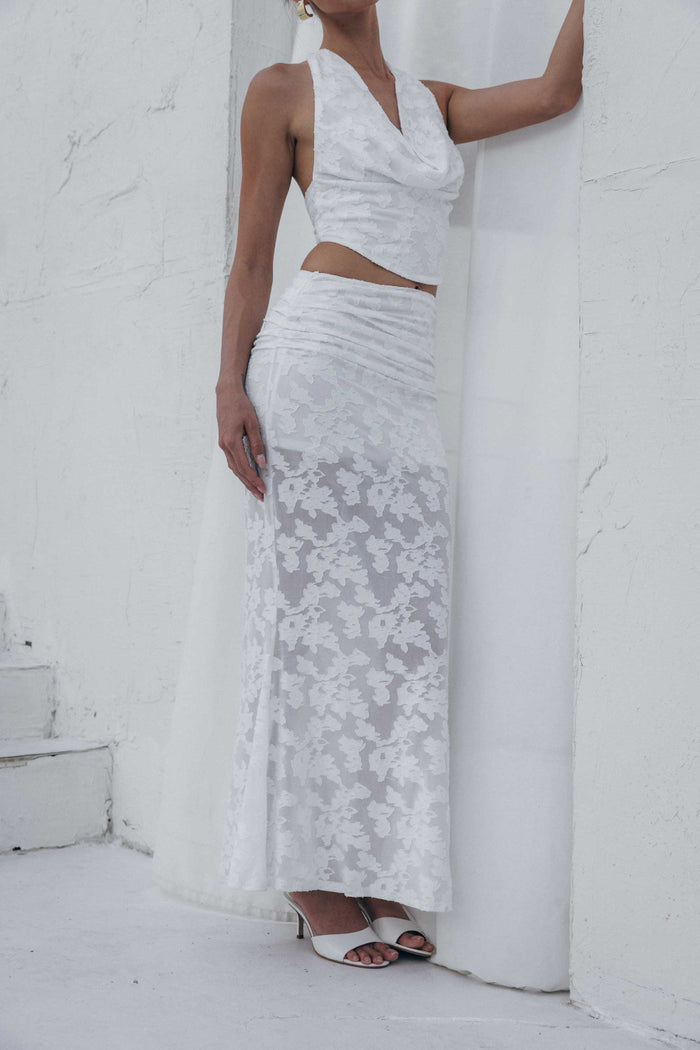 Woman wearing a white lace dress against a white background