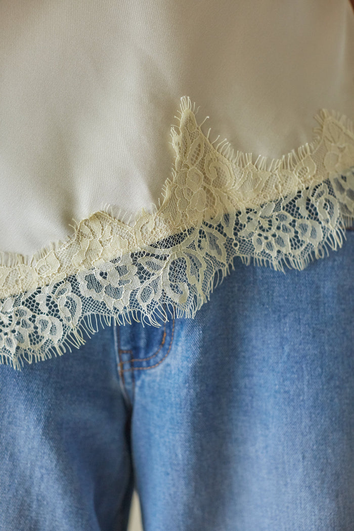 Close-up of a garment with lace trim on a plain background