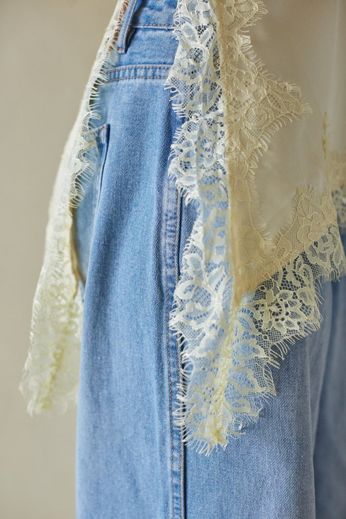 Light blue denim with lace trim top on a neutral background