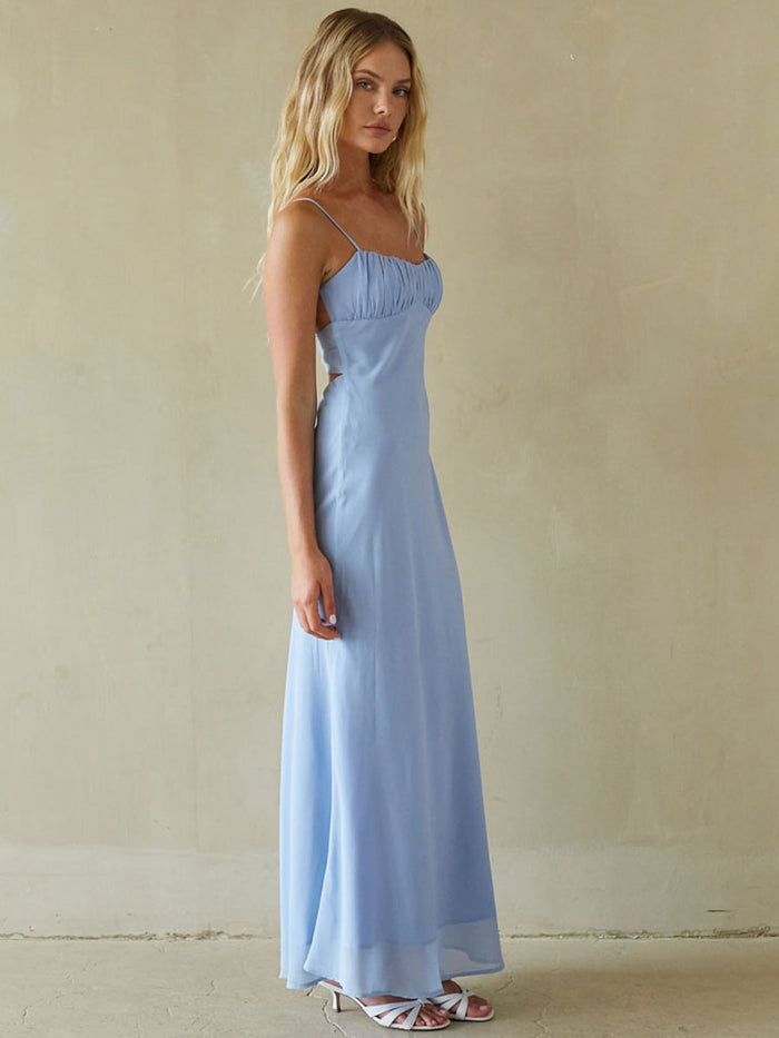Woman wearing a light blue dress against a beige background