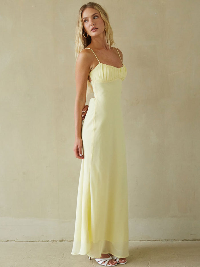 Woman wearing a light yellow dress against a plain background