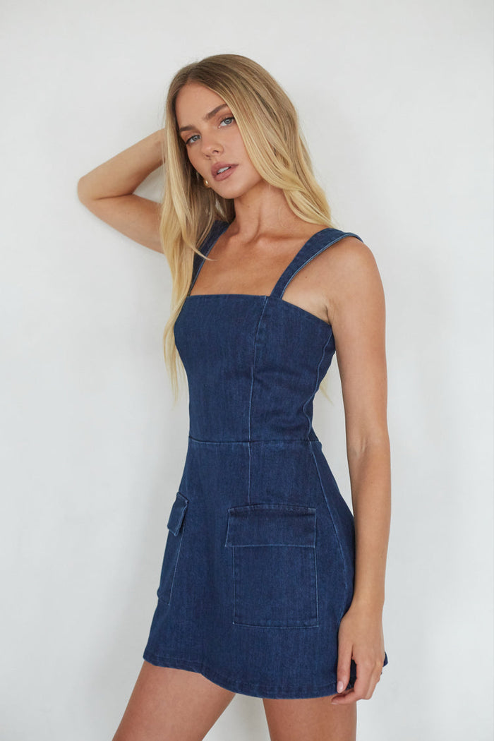 Woman wearing a denim dress against a white background