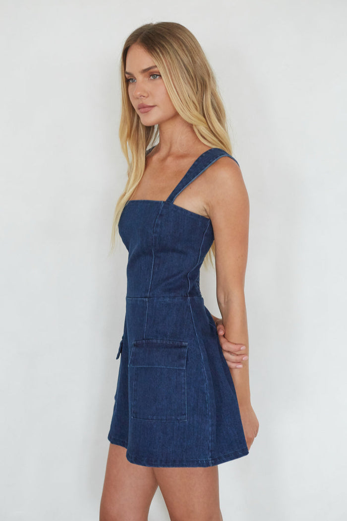 Woman wearing a blue denim dress against a white background